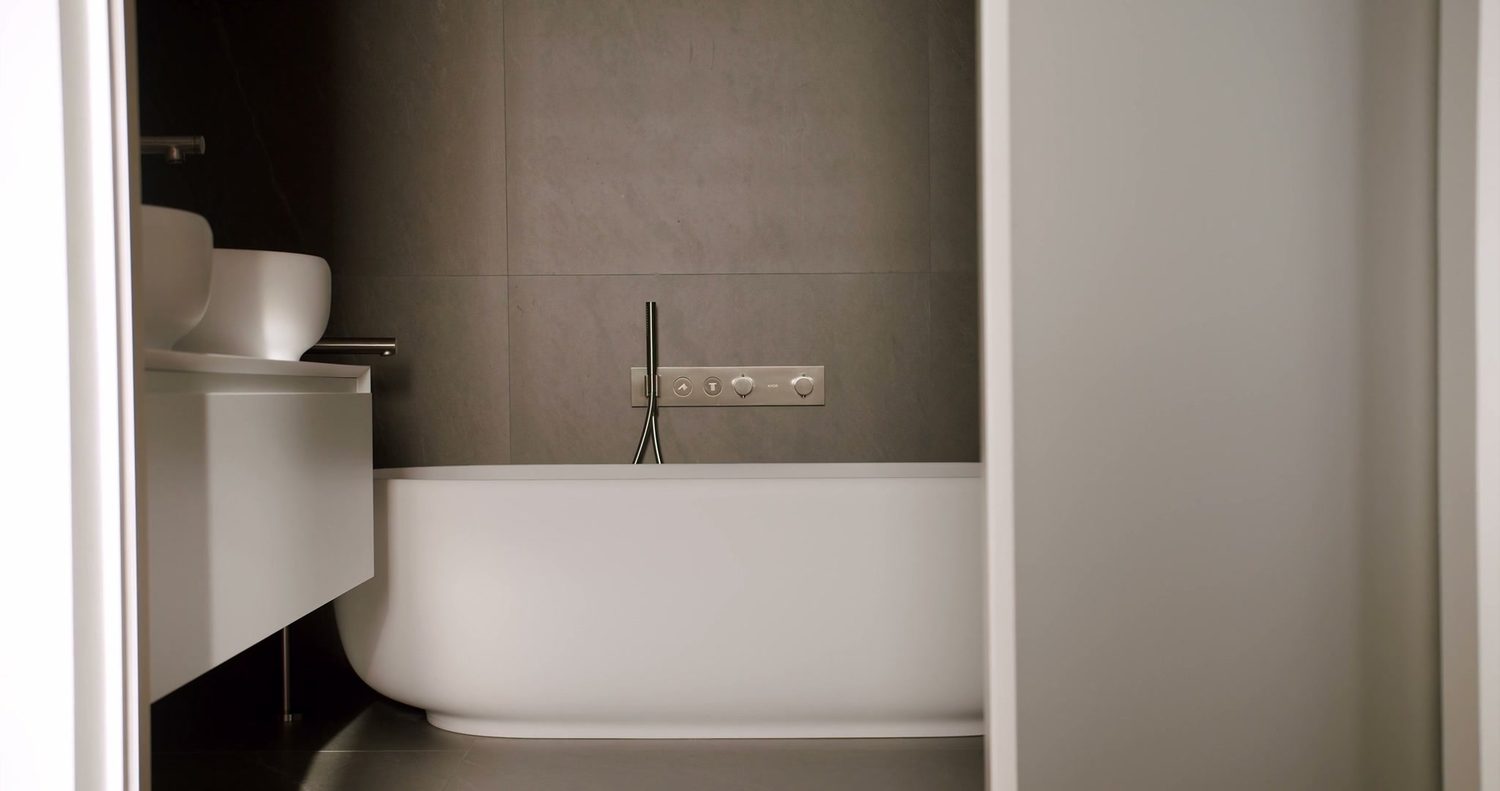 An alcove bathtub with a tiled surround and a recessed shelf niche