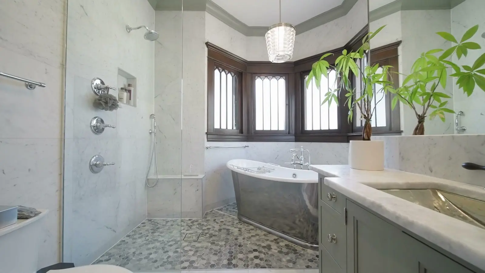 A marble bathroom with a bay window and a mosaic pebble floor