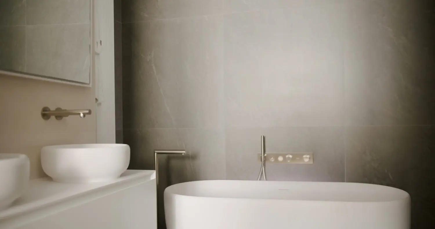 Warm stone bathroom with a round vessel basin and a freestanding soaking tub