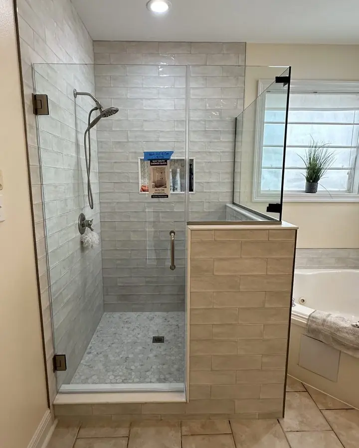 Glass shower enclosure tiled in stone-look porcelain, built where a tub used to sit