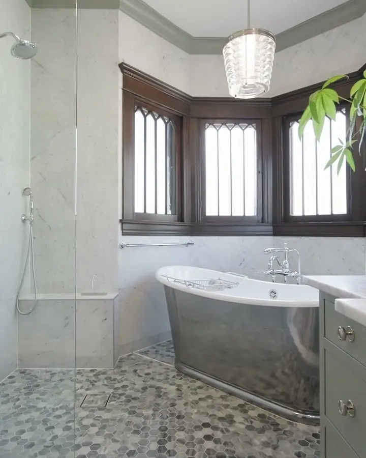 Marble bathroom with a bay window, a built-in tub and a mosaic pebble floor