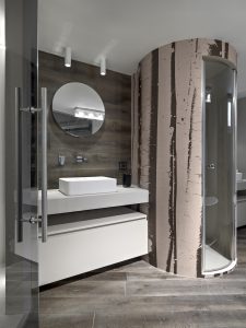interiors shots of a modern bathroom with wooden floor in the foreground the counter top washbasin and the masonry shower cubicle the wall behind the sink is coated of wood