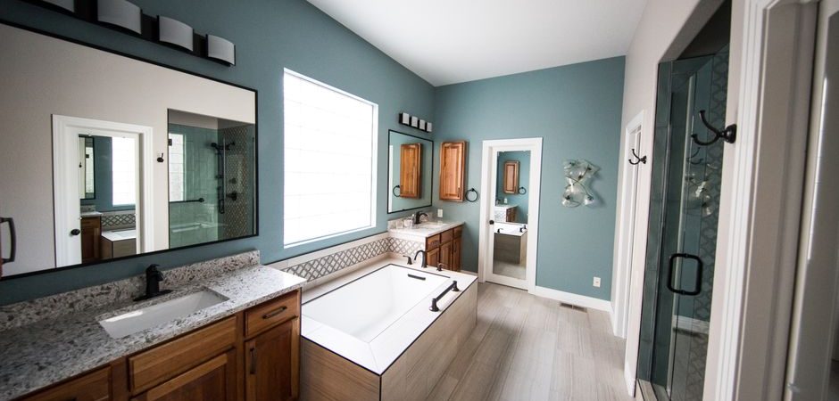 Renovated bathroom with soaking tub, double vanity, and separate glass shower
