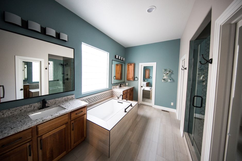 Renovated bathroom with soaking tub, double vanity, and separate glass shower