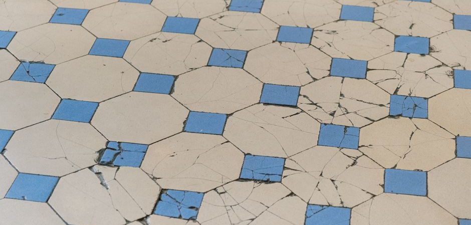 Cracked and worn octagon tile flooring showing signs of damage