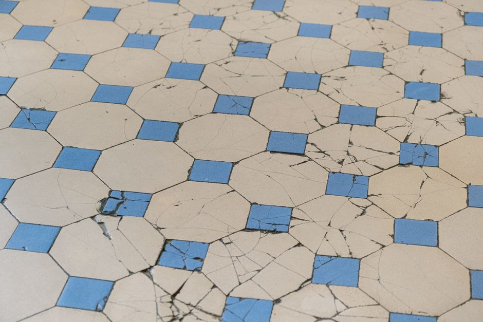 Cracked and worn octagon tile flooring showing signs of damage