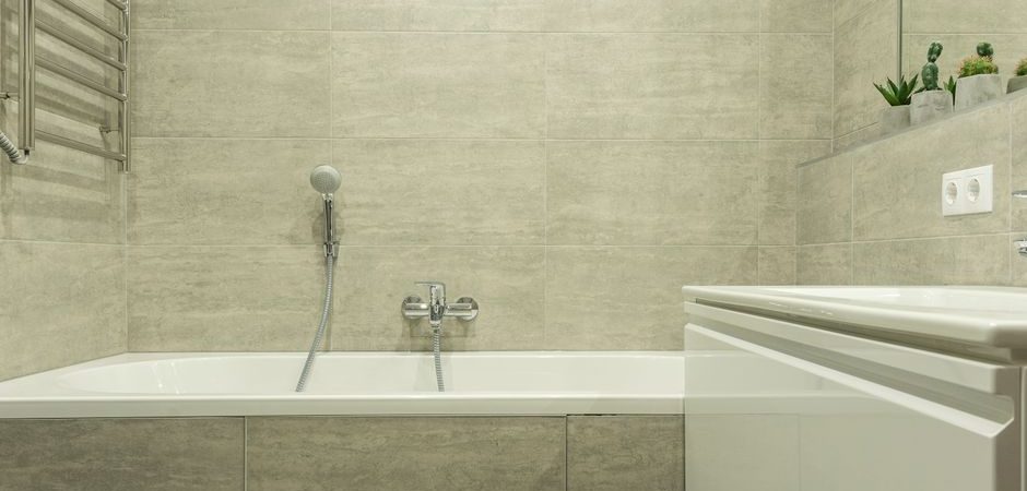Built-in bathtub with handheld shower and tiled surround