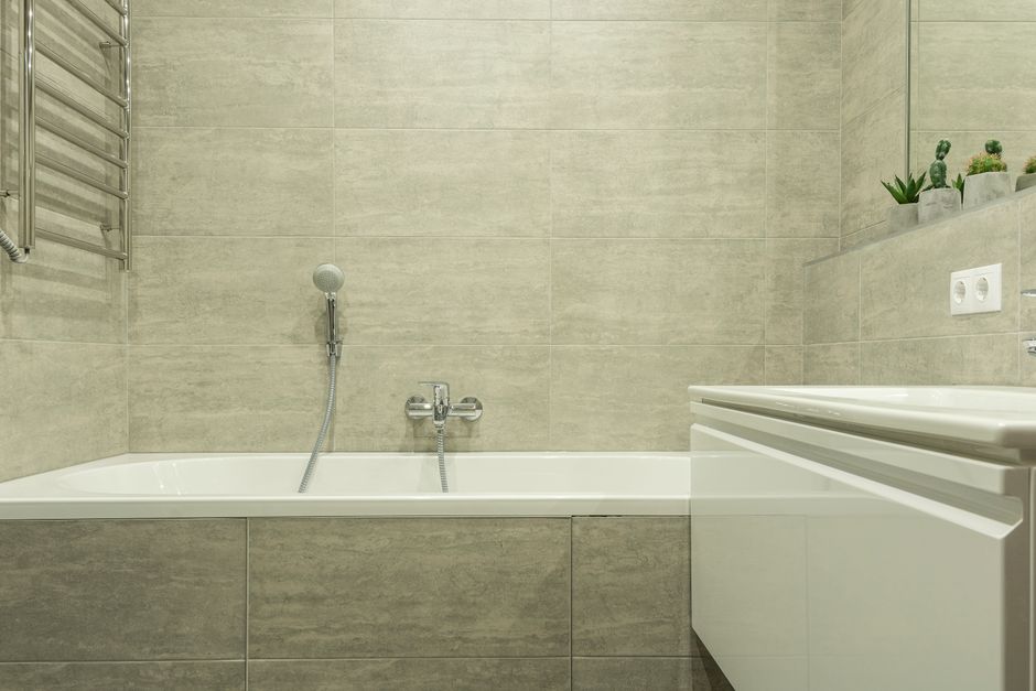Built-in bathtub with handheld shower and tiled surround